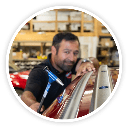 Steven Lozano performing paintless dent repair on a vehicle.