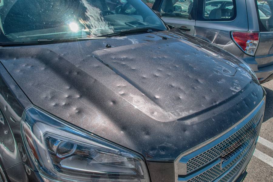 The hood of an SUV in need of auto hail damage repair in Austin, TX.