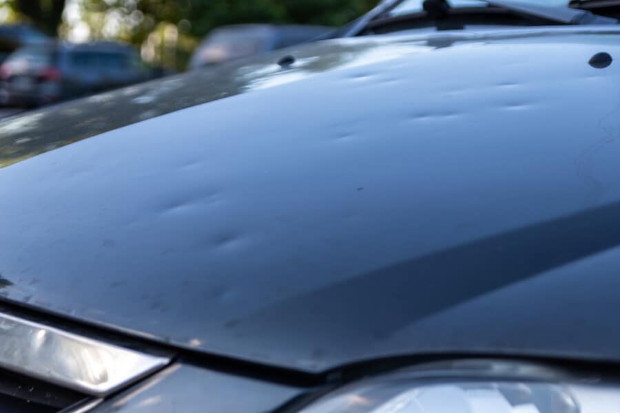 The hood of a hail-damaged car needing dent removal in Austin