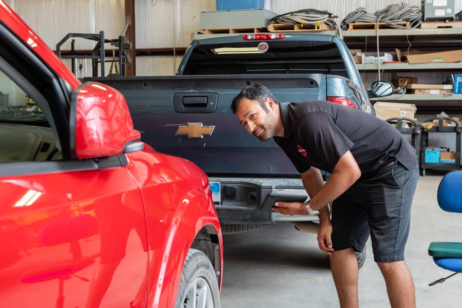 Steven Lozano inspecting a car for hail damage before his interview with KVUE in Austin.