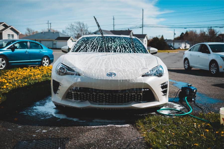 Photo depicting a car being washed and cared for right at the owners home