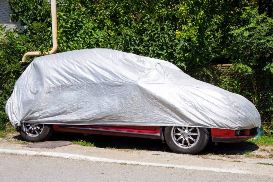 Parked car with a silver protective cover to help avoid needing Austin hail damage repair services