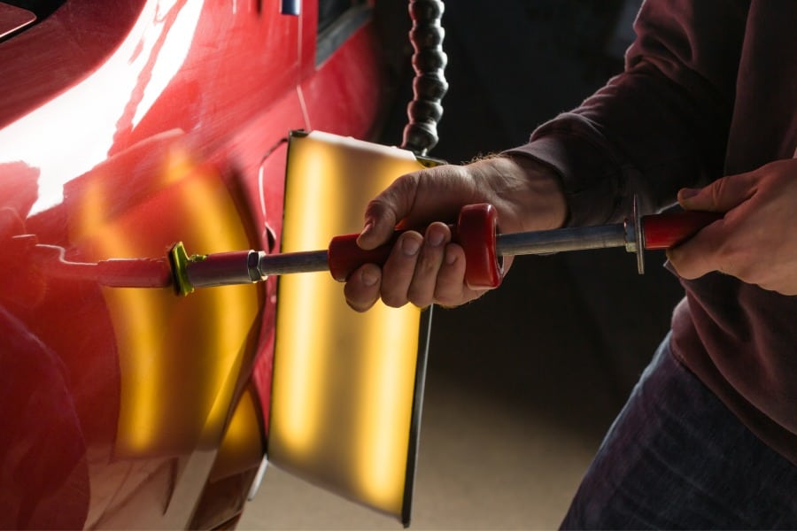 Paintless Dent Repair Specialist removing dents from a vehicle in Austin, TX.