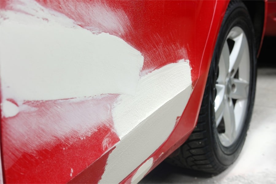 Car body with filler used to fill dents instead of using services for PDR hail damage in Leander.