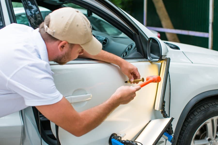 Skilled Car Hail Damage Repair in Leander Technician Working to Hammer Out some Dents