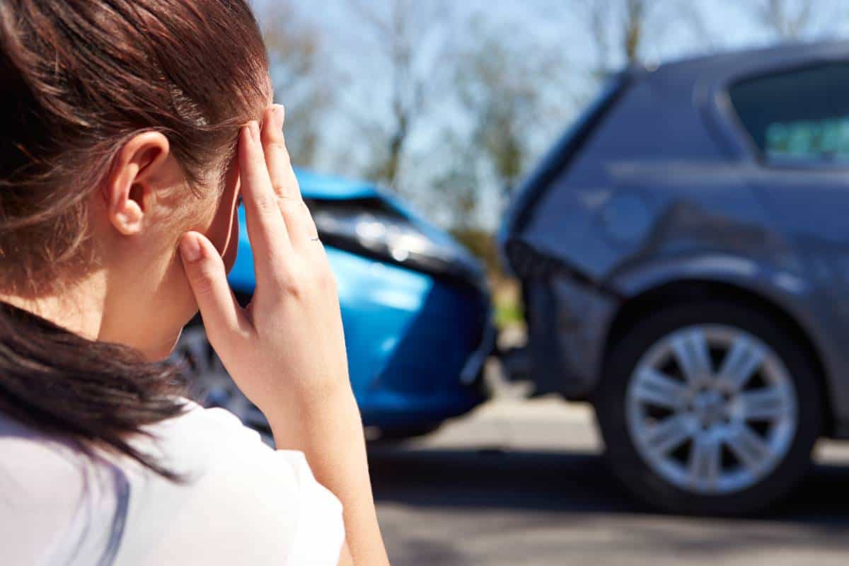 driver looking at her car after a minor auto accident needing Cedar Park paintless dent repair