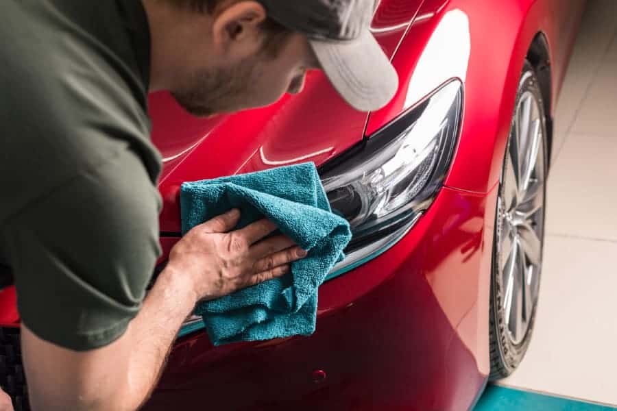 Polishing the headlight of a red car