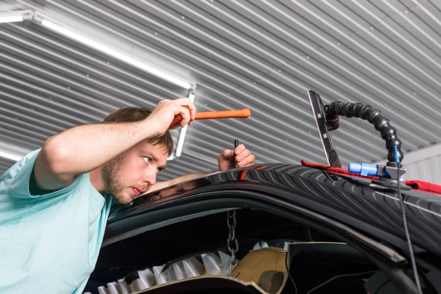 An image of a dent specialist Removing dents on a car body without painting