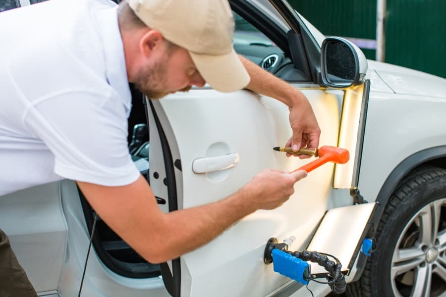 A technician looking working on a car after providing an Austin PDR estimate.