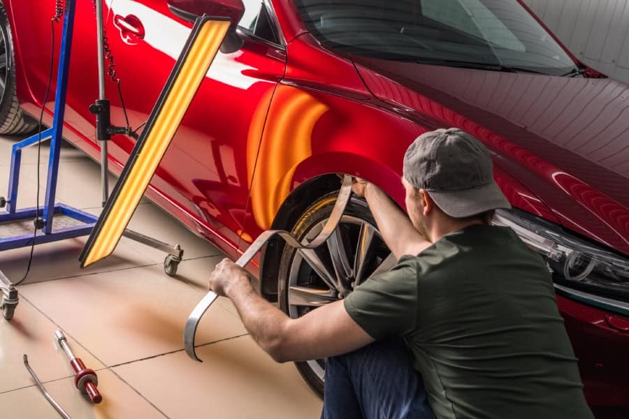 Mechanic repairing car dent